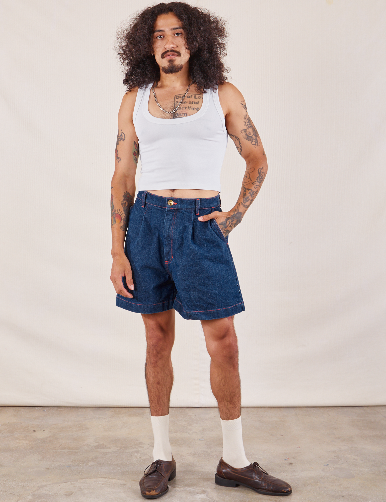 Jesse is 5'8" and wearing S Denim Trouser Shorts in Dark Wash paired with a Cropped Tank in vintage tee off-white