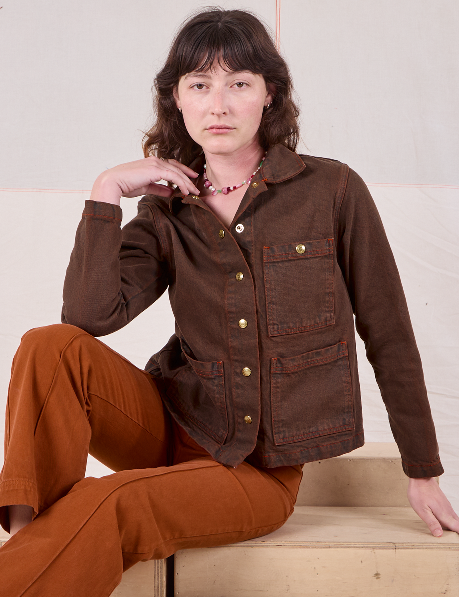 Alex is wearing Overdyed Denim Work Jacket in Fudge paired with burnt terracotta Western Pants