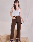 Hana is 5'3" and wearing XXS Petite Overdyed Carpenter Jeans in Fudge paired with a Cropped Tank in vintage tee off-white