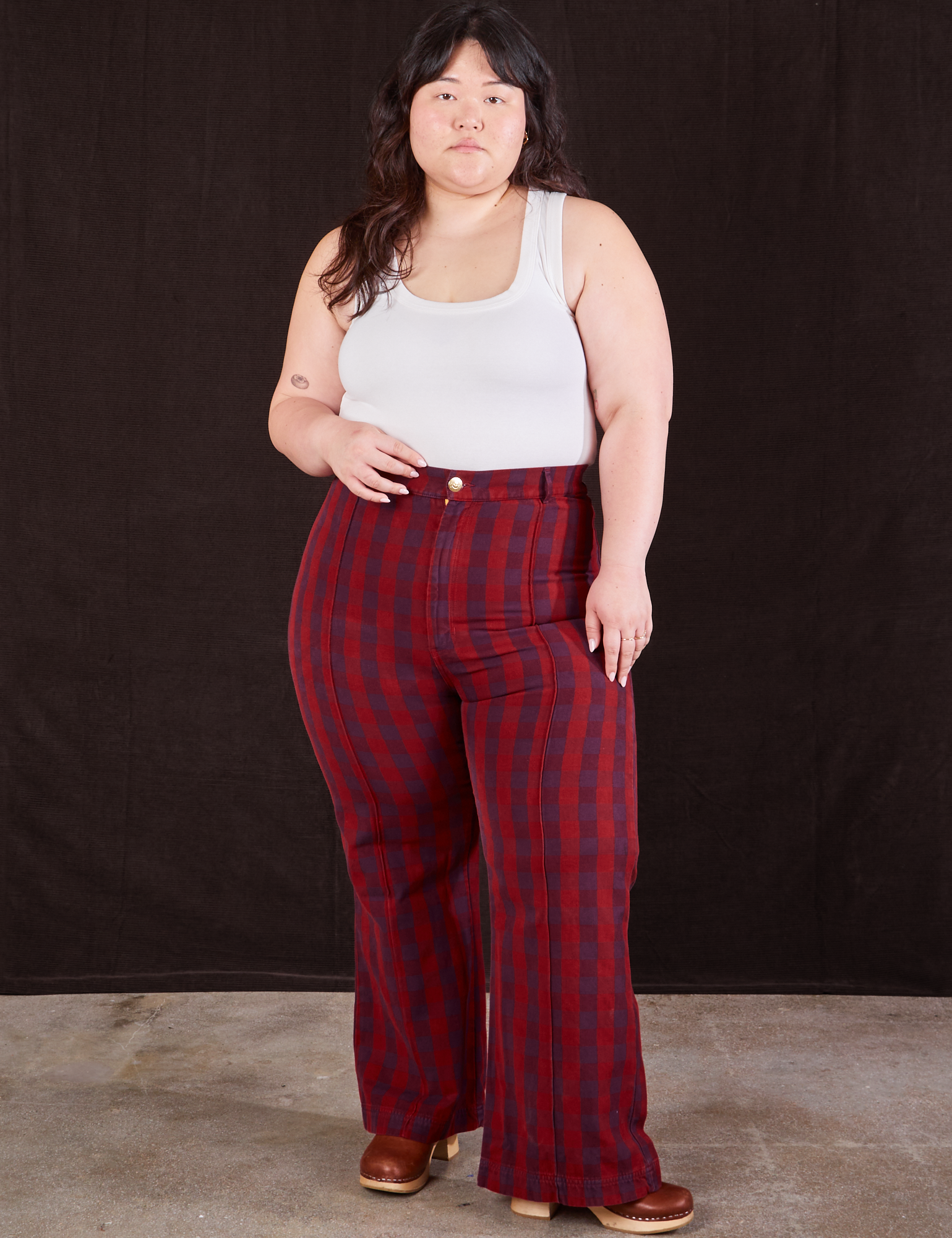 Ashley is 5'7" and wearing 0XL Gingham Western Pants in Cranberry Red paired with a Cropped Tank in vintage tee off-white