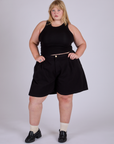 Juliet is 5’7” and wearing 2XL Pleated Trouser Shorts in Basic Black paired with black Racerback Tank