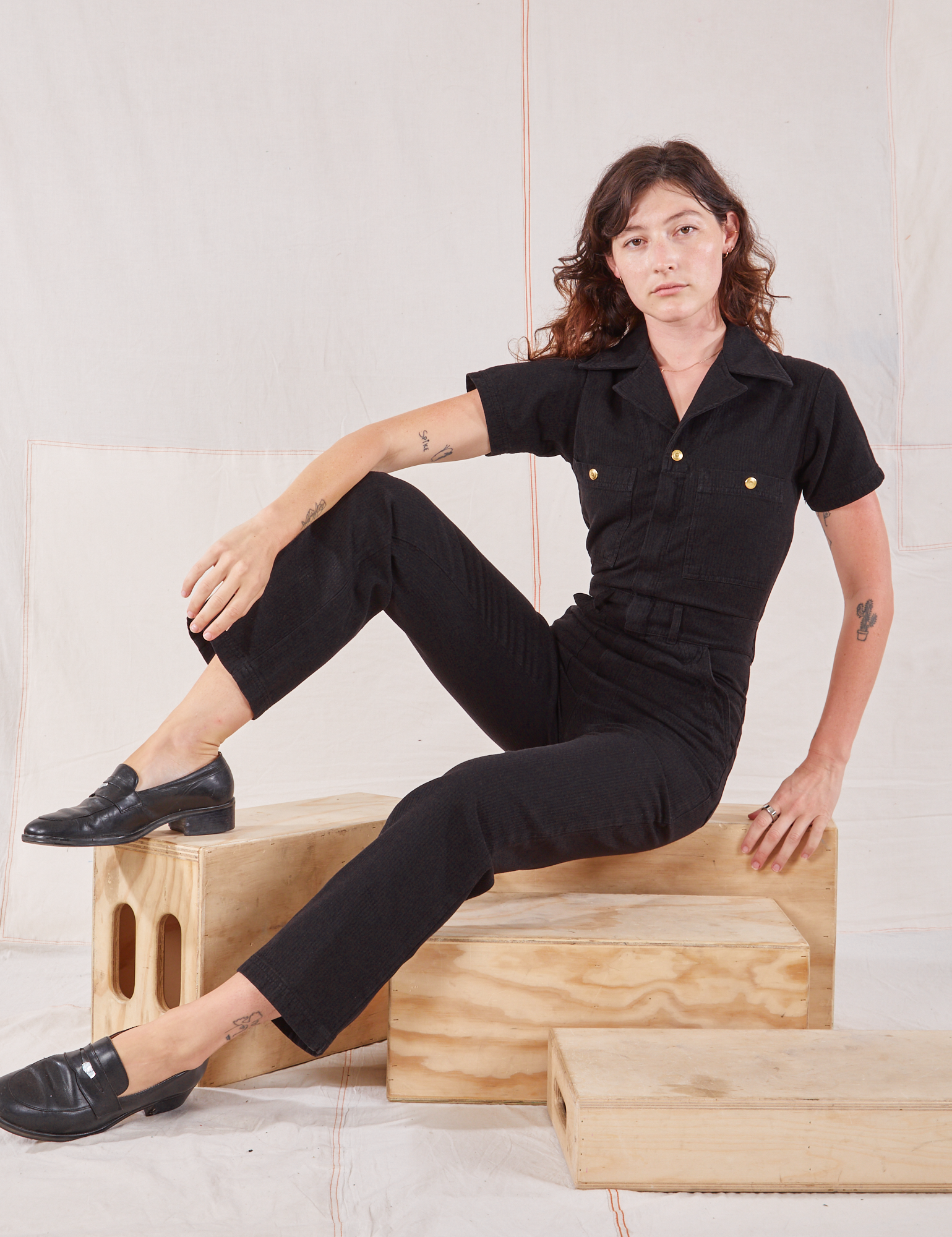 Alex is wearing Heritage Short Sleeve Jumpsuit in Basic Black