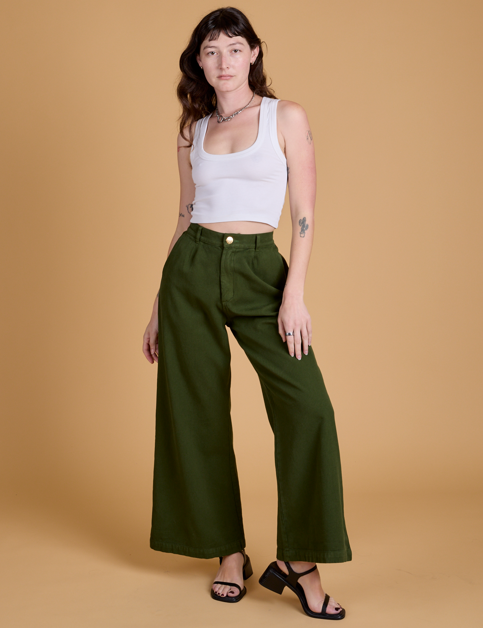 Alex is 5'8" and wearing XXS Heritage Wide Leg Trousers in Evergreen paired with a vintage tee white Cropped Tank