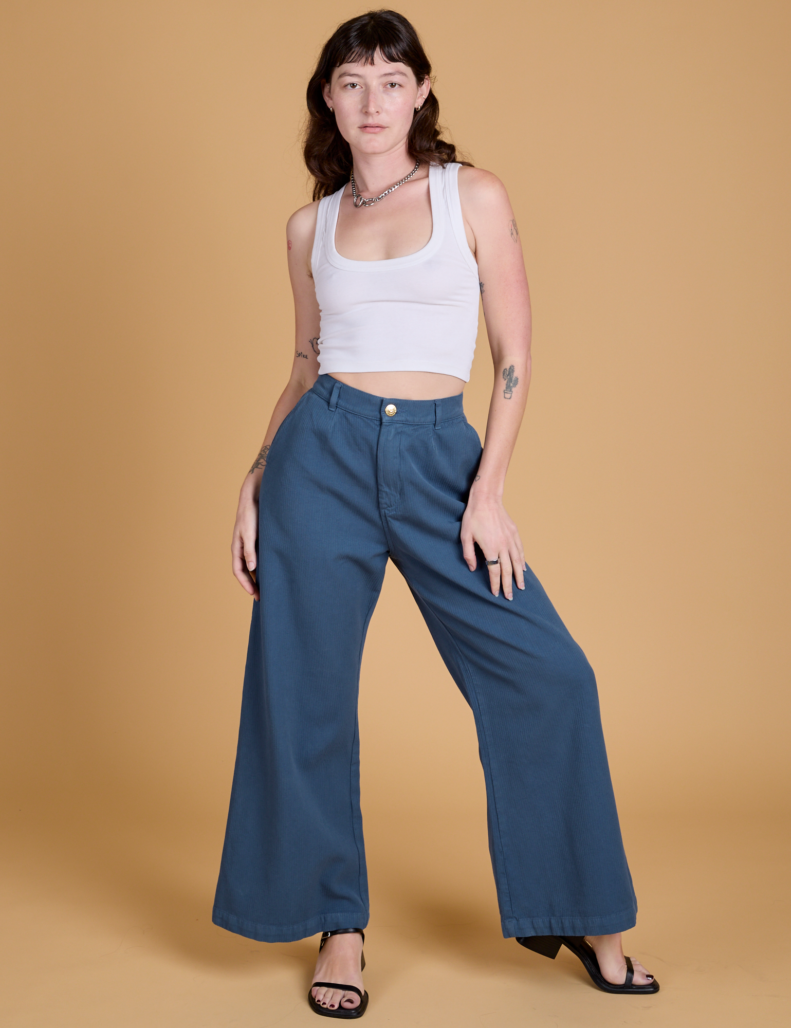 Alex is 5'8" and wearing XXS Heritage Wide Leg Trousers in French Blue paired with vintage tee white Cropped Tank