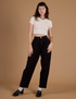 Alex is 5’8” and wearing XXS Heritage Trousers in Basic Black paired with vintage off white Cropped Baby Tee