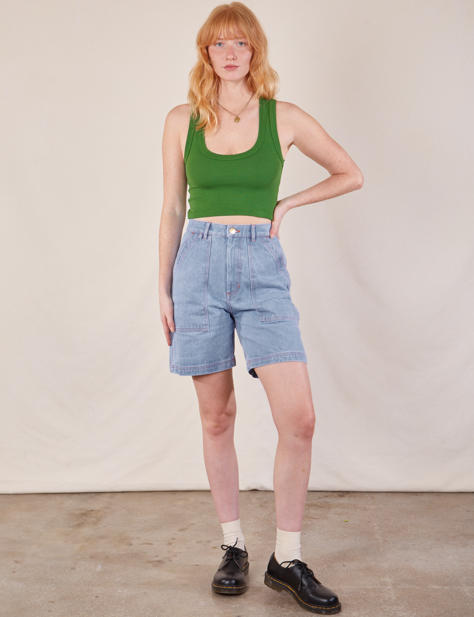 Margaret is 5'11" and wearing XS Carpenter Shorts in Light Wash paired with a lawn green Cropped Tank