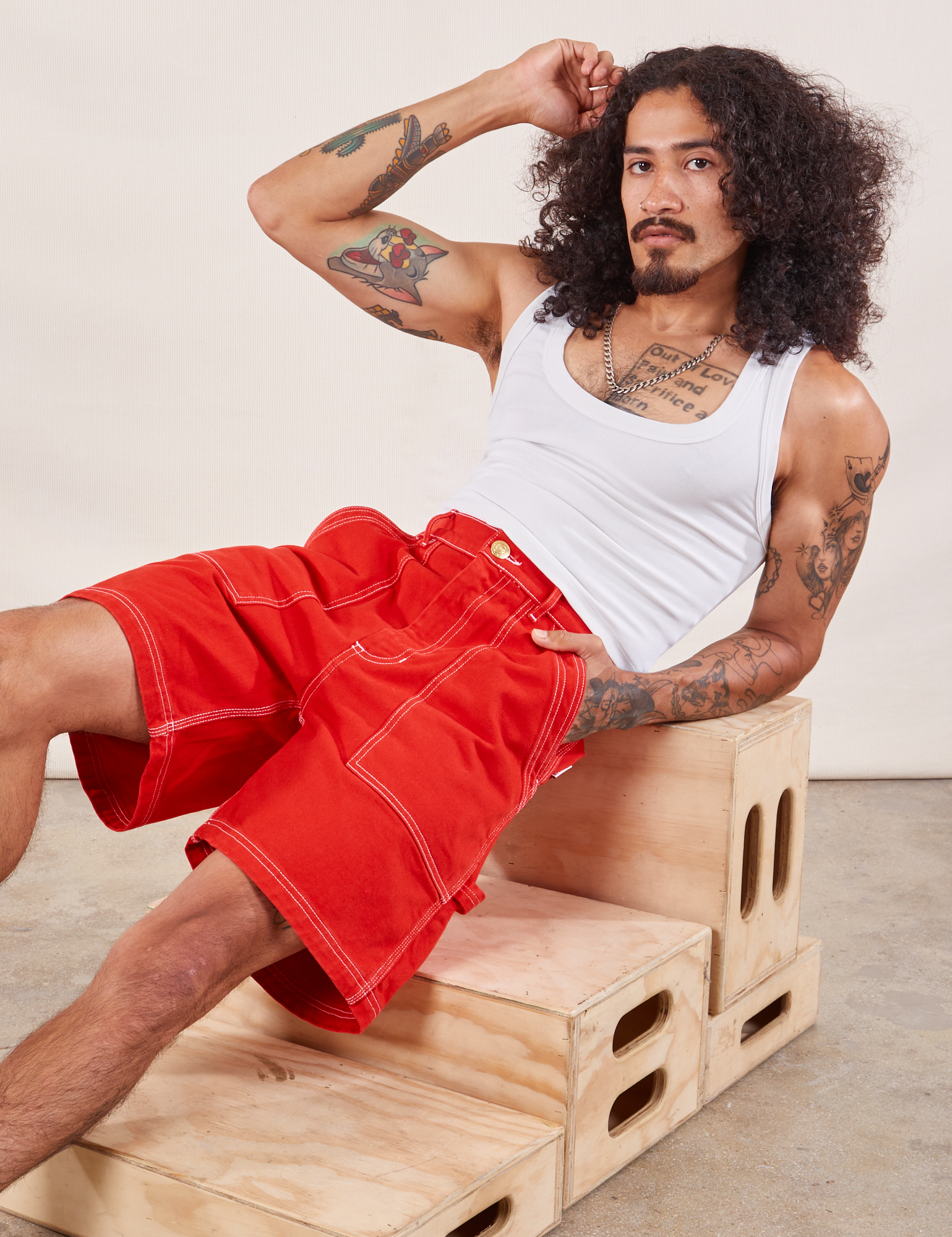 Jesse is wearing Carpenter Shorts in Mustang Red paired with a Cropped Tank in vintage tee off-white