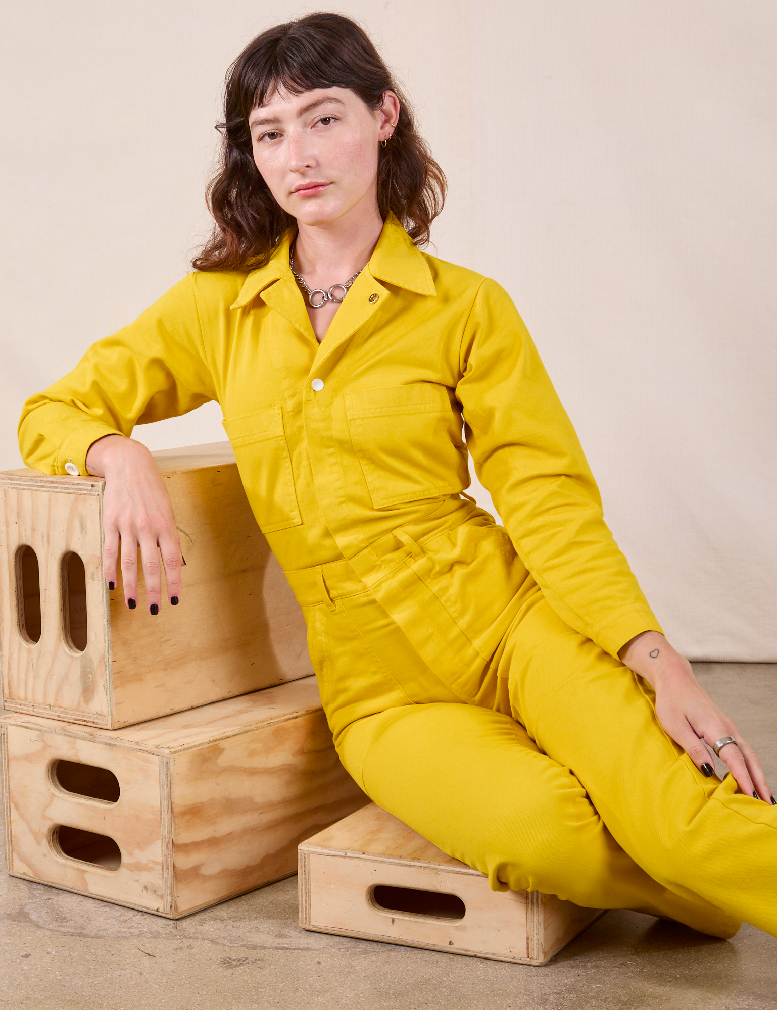 Alex is wearing Long Sleeve Jumpsuit in Golden Yellow