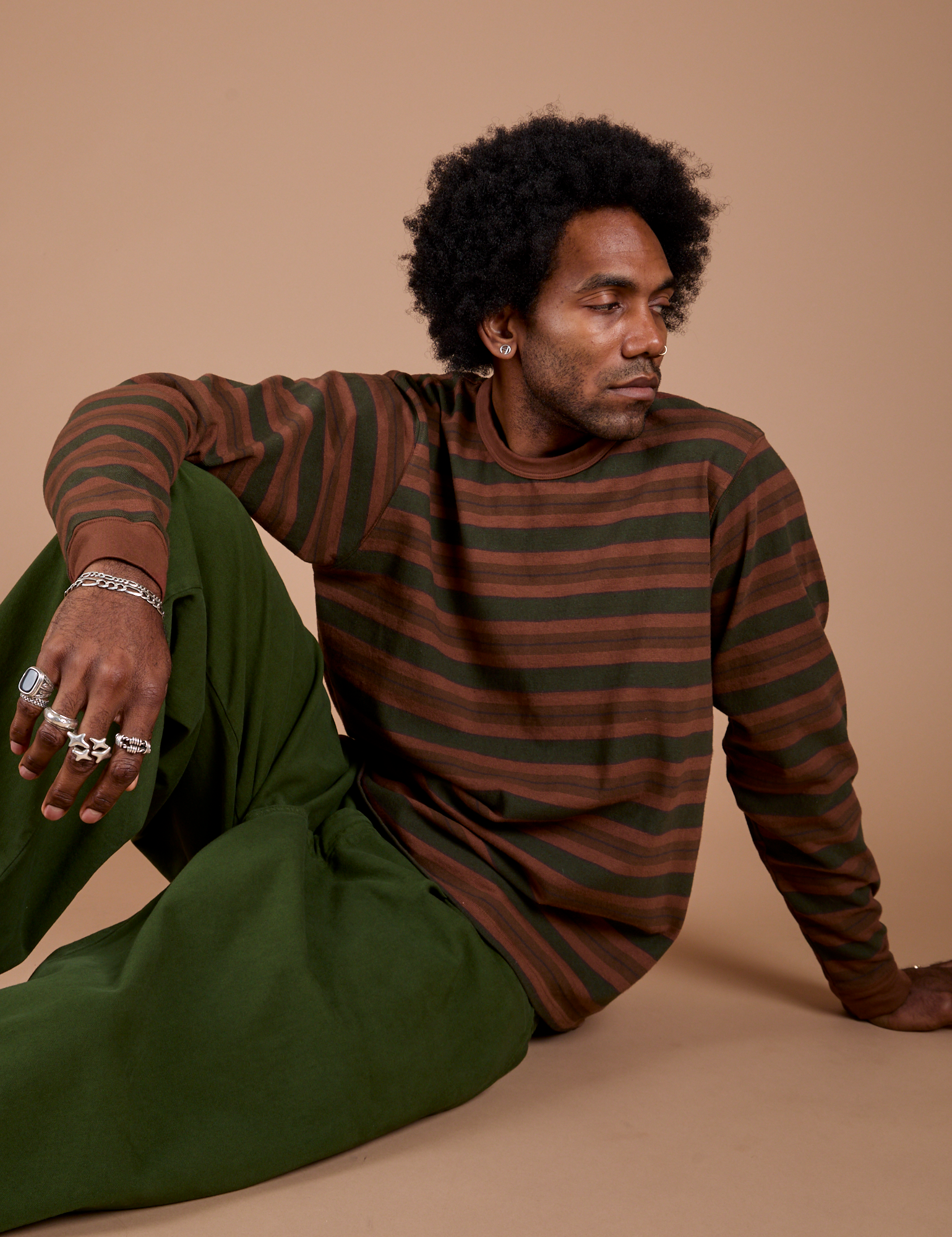 Jerrod is wearing Long Sleeve Striped Burly Tee in Fudgesicle paired with Drop Pocket Cargo Pants in Evergreen