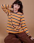 Alex is 5’8” and wearing P Long Sleeve Striped Burly Tee in Orange