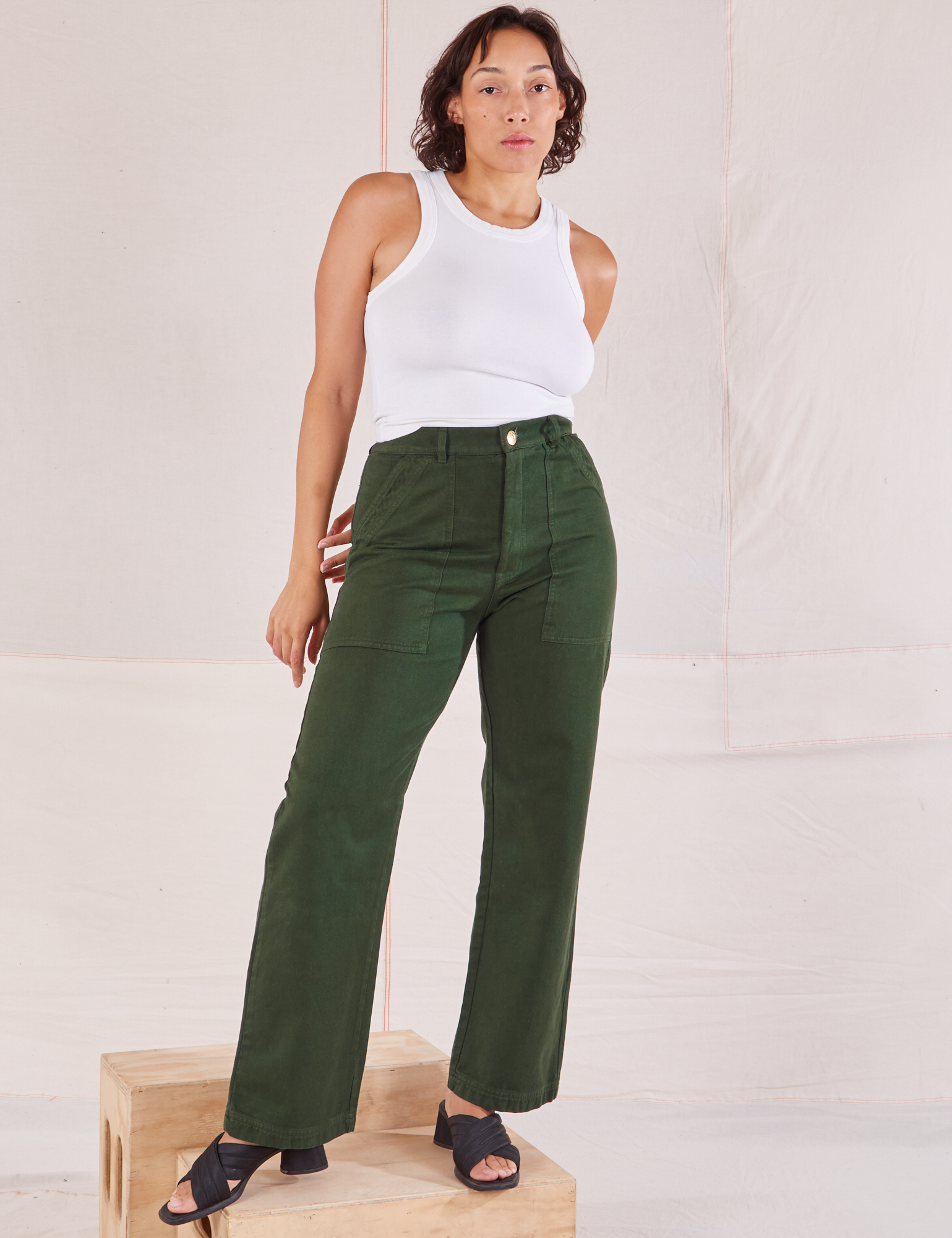 Tiara is 5&#39;4&quot; and wearing S Organic Work Pants in Swamp Green paired with a Racerback Tank in vintage tee off-white