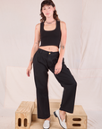 Alex is 5'8" and wearing XXS Mid-Rise Pleated Trousers in Basic Black paired with a black Cropped Tank