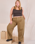 Juliet is 5'7" and wearing 0XL Mid-Rise Pleated Trousers in Desert Brown paired with espresso brown Cropped Tank