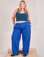 Juliet is 5'7" and wearing 0XL Mid-Rise Pleated Trousers in Royal Blue paired with a lagoon Cropped Tank