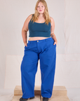 Juliet is 5'7" and wearing 0XL Mid-Rise Pleated Trousers in Royal Blue paired with a lagoon Cropped Tank