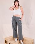 Alex is 5'8" and wearing XXS Mid-Rise Pleated Trousers in Slate Grey paired with Cropped Tank in vintage tee off-white