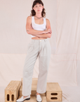 Alex is 5'8" and wearing XXS Mid-Rise Pleated Trousers in Stone White paired with a Cropped Tank in vintage tee off-white