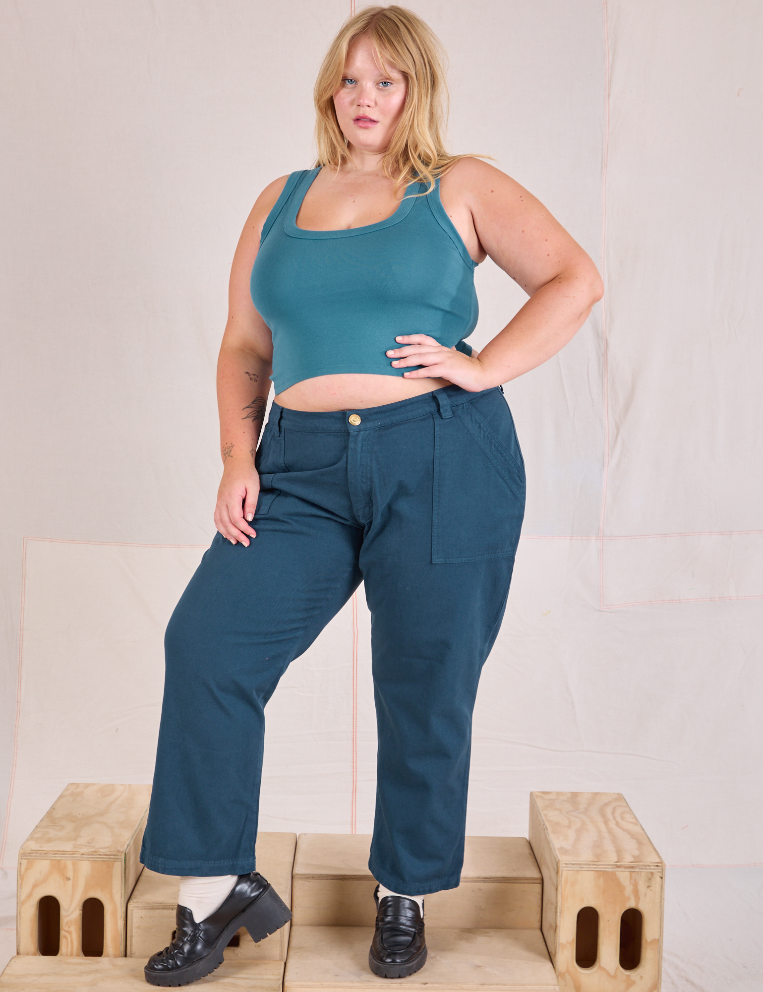 Juliet is 5'7" and wearing 2XL Mid-Rise Work Pants in Lagoon paired with marine blue Cropped Tank