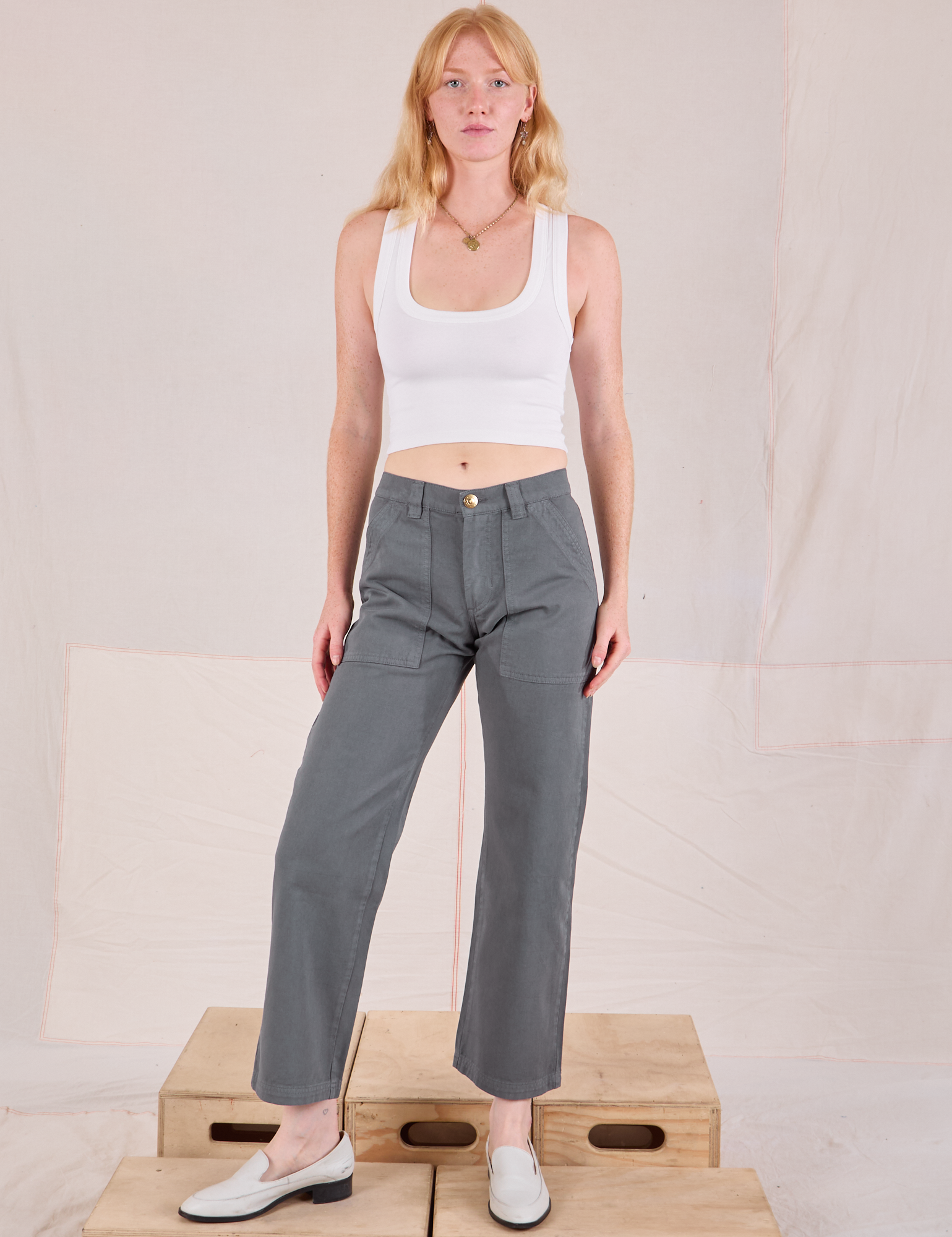 Margaret is 5'11" and wearing XS Mid-Rise Work Pants in Slate Grey paired with a Cropped Tank in vintage tee off-white