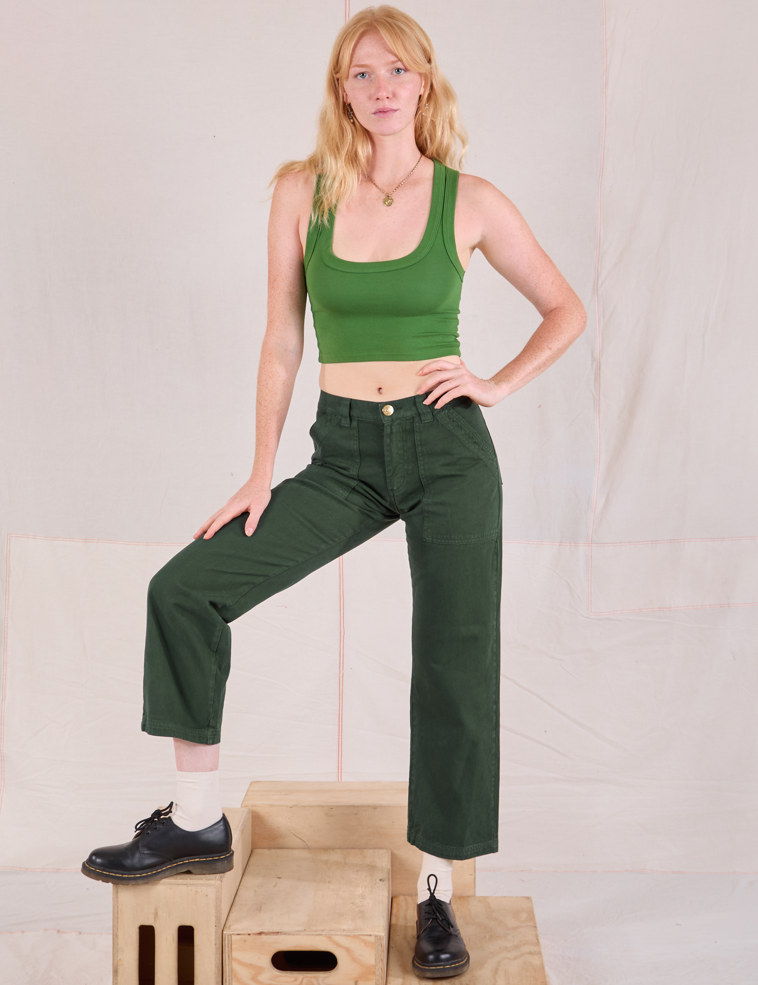 Margaret is 5'11" and wearing XS Mid-Rise Work Pants in Swamp Green paired with lawn green Cropped Tank