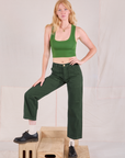 Margaret is 5'11" and wearing XS Mid-Rise Work Pants in Swamp Green paired with lawn green Cropped Tank