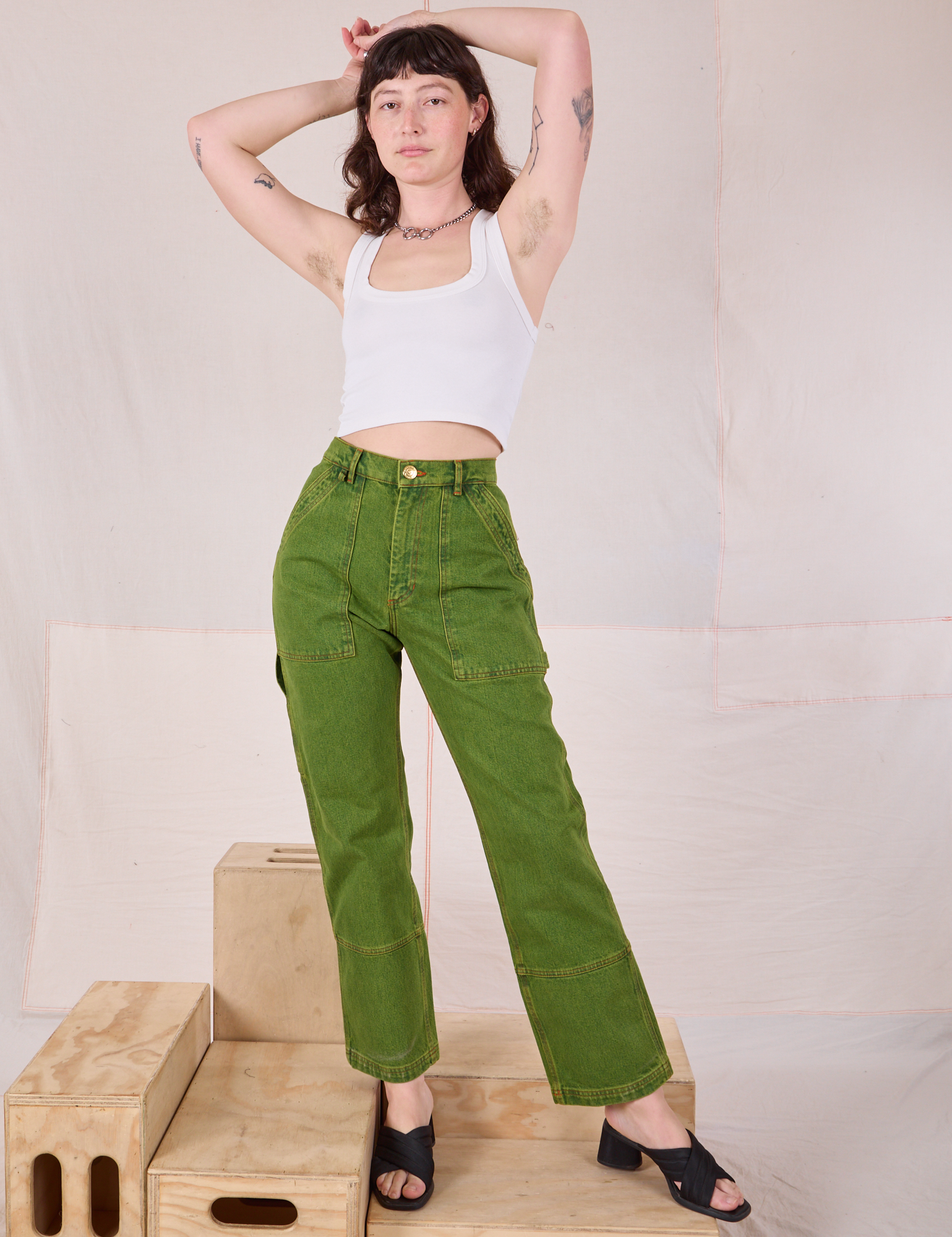 Alex is 5’8” and wearing size XXS Overdyed Carpenter Jeans in Gross Green paired with a Cropped Tank in Vintage Tee Off-White