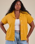 Meghna is 5’8” and wearing M Pantry Button-Up in Mustard Yellow