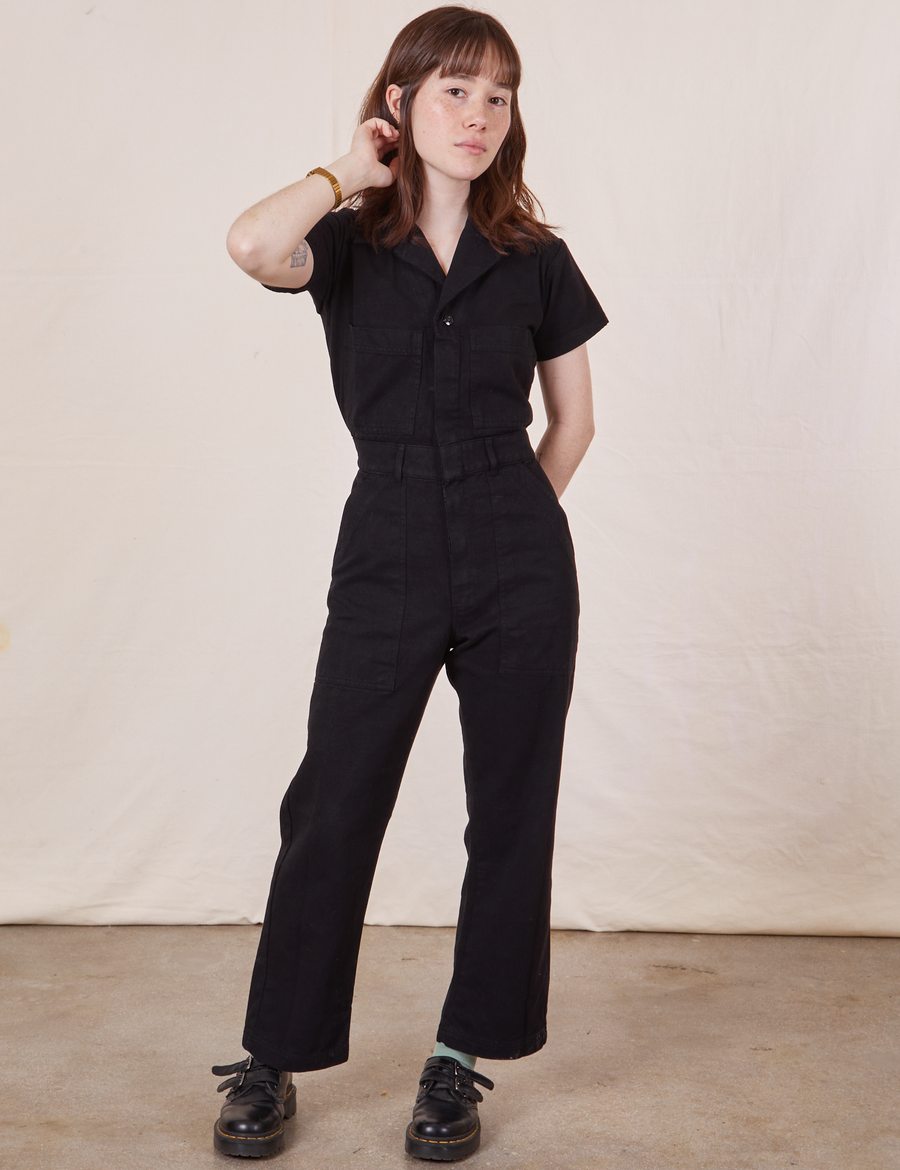 Hana is 5’3” and wearing XXS Petite Short Sleeve Jumpsuit in Basic Black