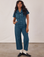 Kandia is 5'3" and wearing XS Petite Short Sleeve Jumpsuit in Lagoon