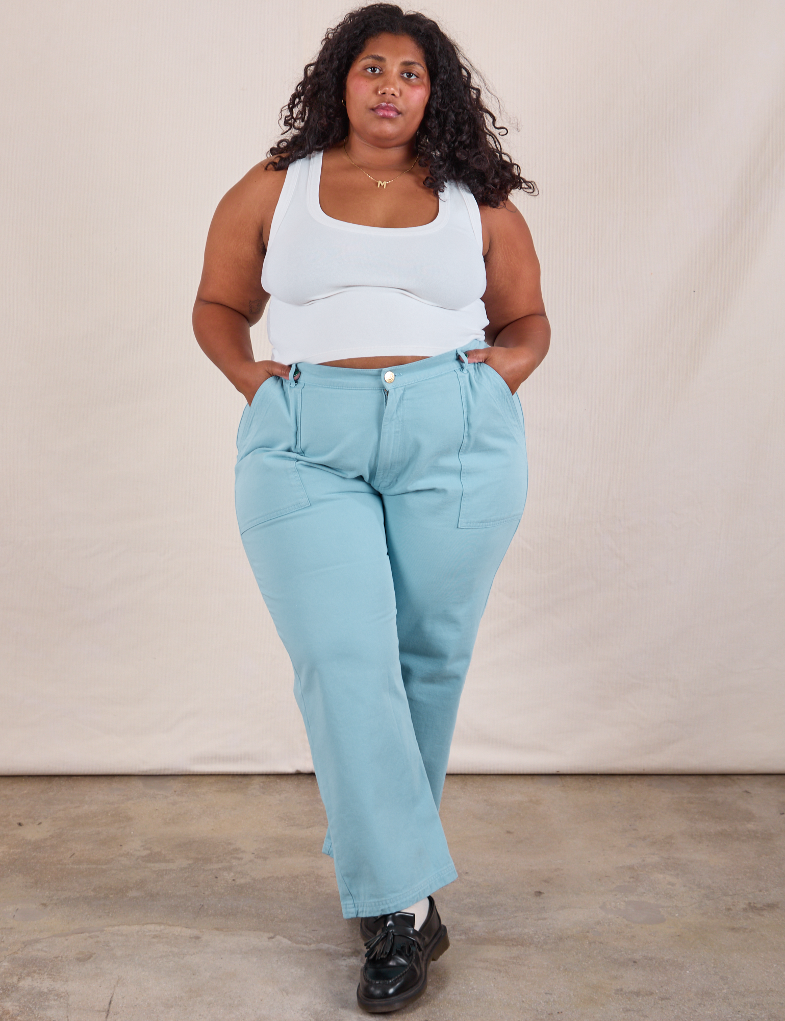 Morgan is 5'5" and wearing 2XL Work Pants in Baby Blue paired with a Cropped Tank in vintage tee off-white