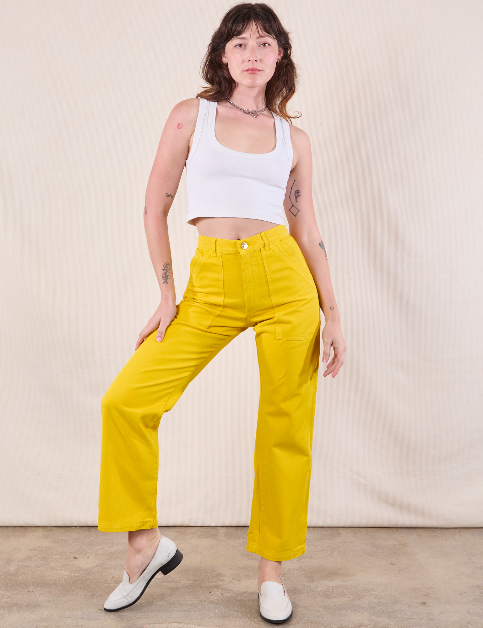 Alex is 5&#39;8&quot; and wearing XXS Work Pants in Golden Yellow paired with a Cropped Tank in Vintage Tee Off-White