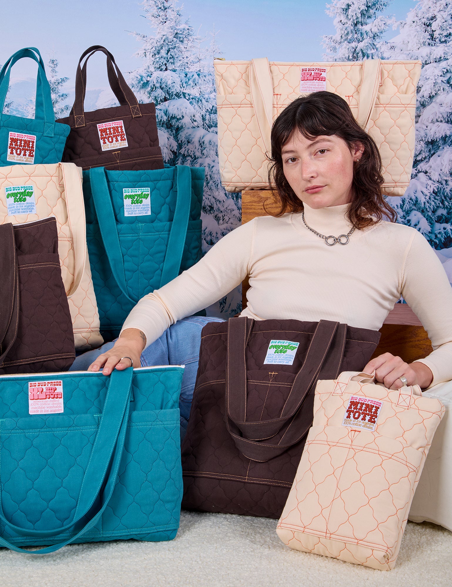 Alex is surrounded by Quilted Totes in Marine Blue, Espresso Brown and Vintage Tee Off-White