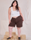 Ashley is 5'7" and wearing 1XL Railroad Carpenter Shorts in Fudgesicle Brown paired with a Cropped Tank in Vintage Tee Off-White