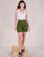 Alex is 5'8" and wearing XXS Railroad Carpenter Shorts in Summer Olive paired with a Cropped Tank in Vintage Tee Off-White