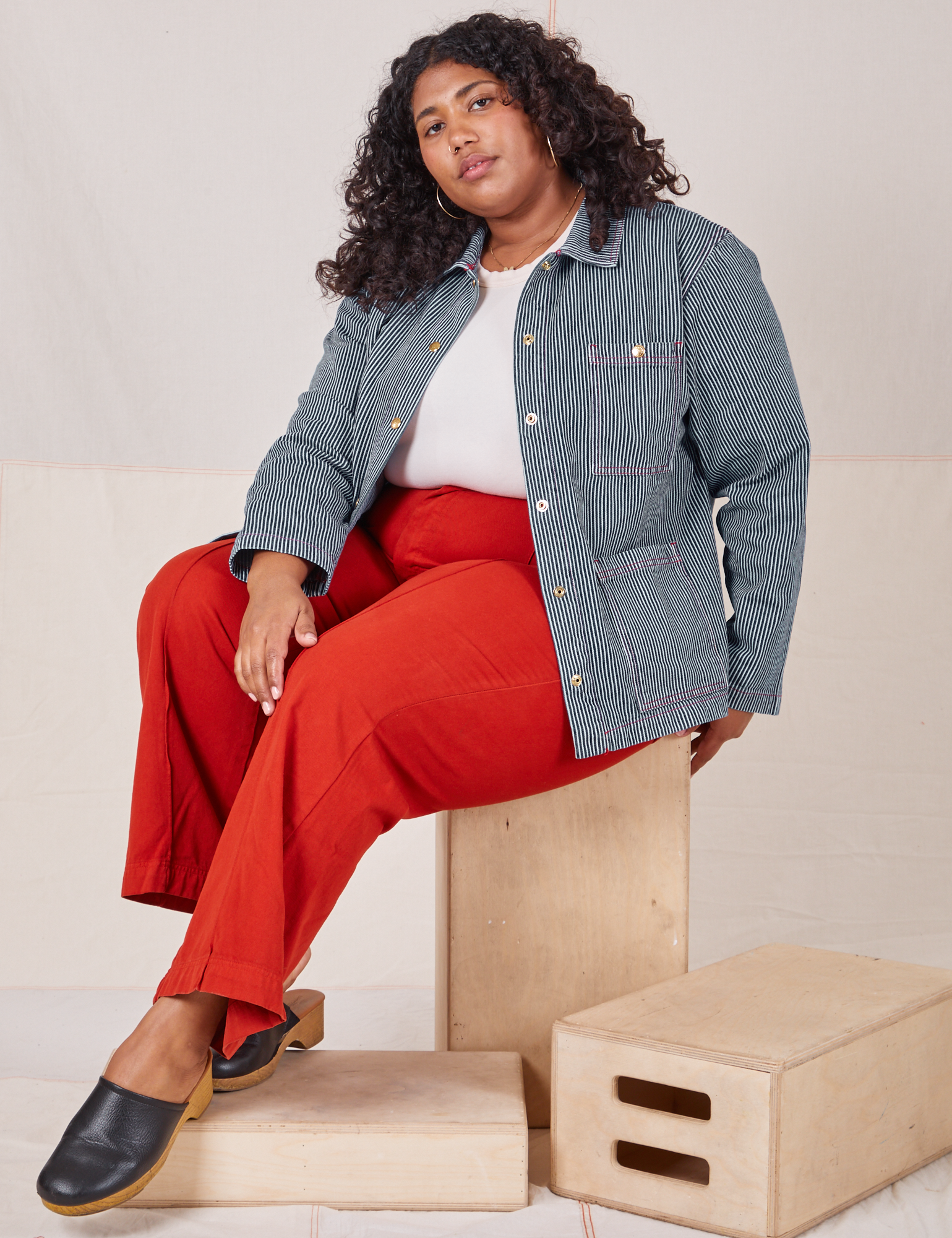 Morgan is 5'5" and wearing 1XL Railroad Stripe Denim Work Jacket paired with paprika Western Pants
