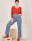 Tiara is 5'4" and wearing S Railroad Stripe Denim Work Pants paired with a paprika Long Sleeve V-Neck Tee