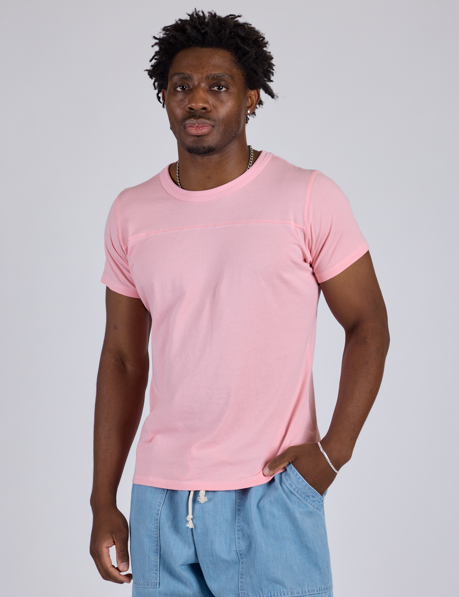 Isaac is 5’10” and wearing M Jr. Varsity Tee in Baby Pink