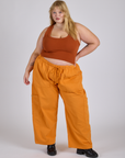 Juliet is 5’7” and wearing 2XL Drop Pocket Cargo Pants in Creamsicle Orange paired with burnt terracotta Cropped Tank