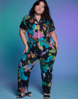 Ashley is 5'7" and wearing 1XL Short Sleeve Jumpsuit in Rainbow Magic Waters