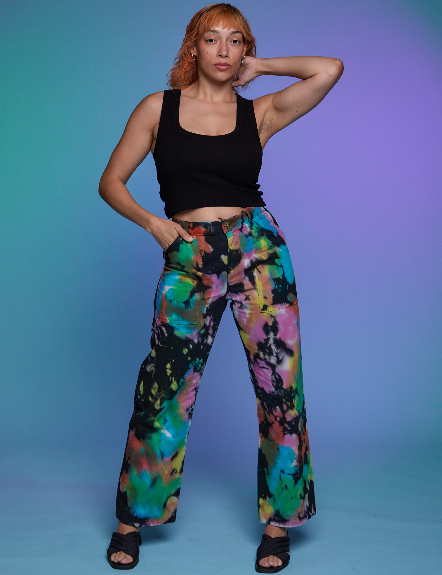 Tiara is 5'4" and wearing S Work Pants in Rainbow Magic Waters paired with a black Cropped Tank