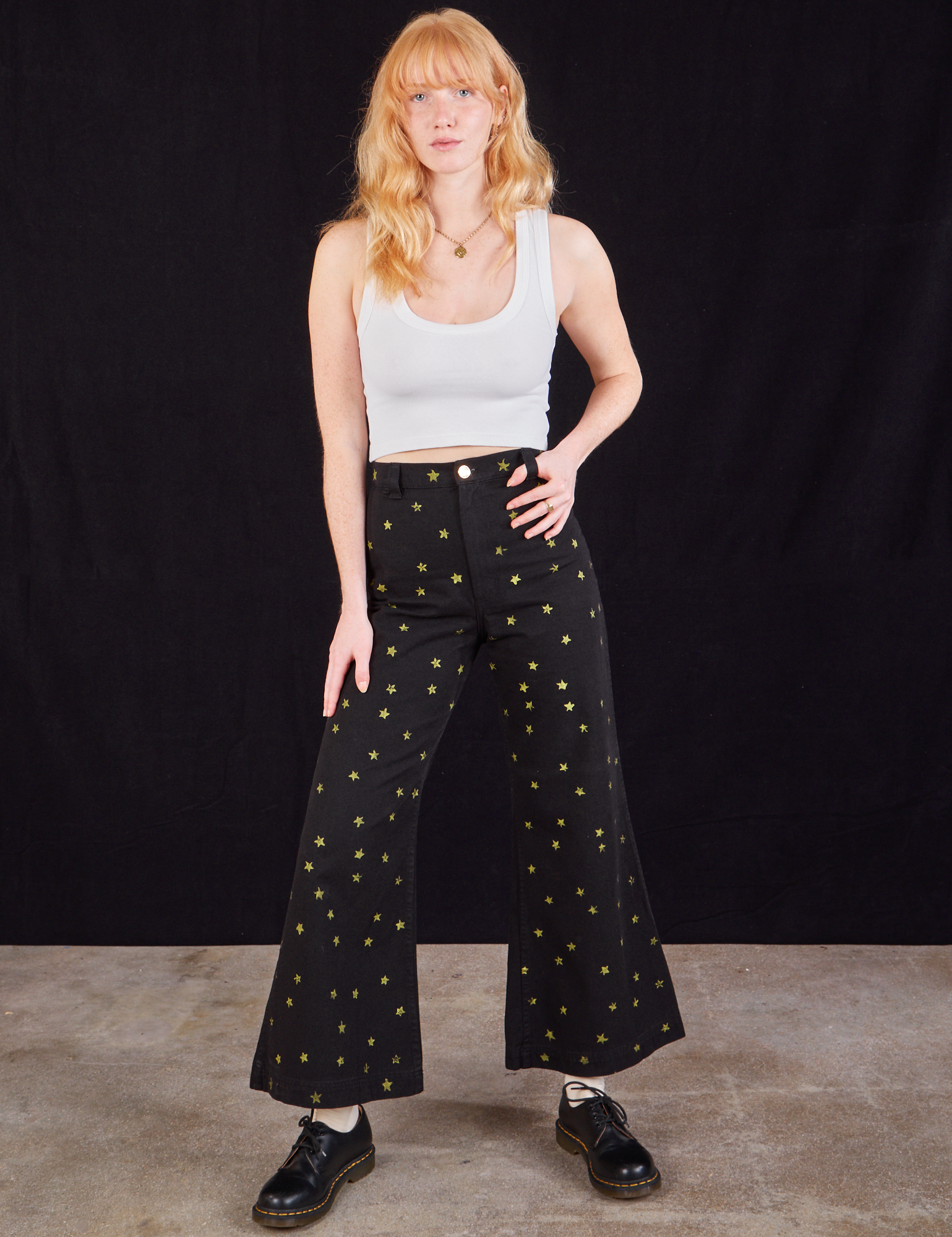 Margaret is 5&#39;11&quot; and wearing XXS Star Bell Bottoms in Black paired with a Cropped Tank in vintage tee off-white