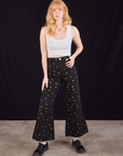 Margaret is 5'11" and wearing XXS Star Bell Bottoms in Black paired with a Cropped Tank in vintage tee off-white