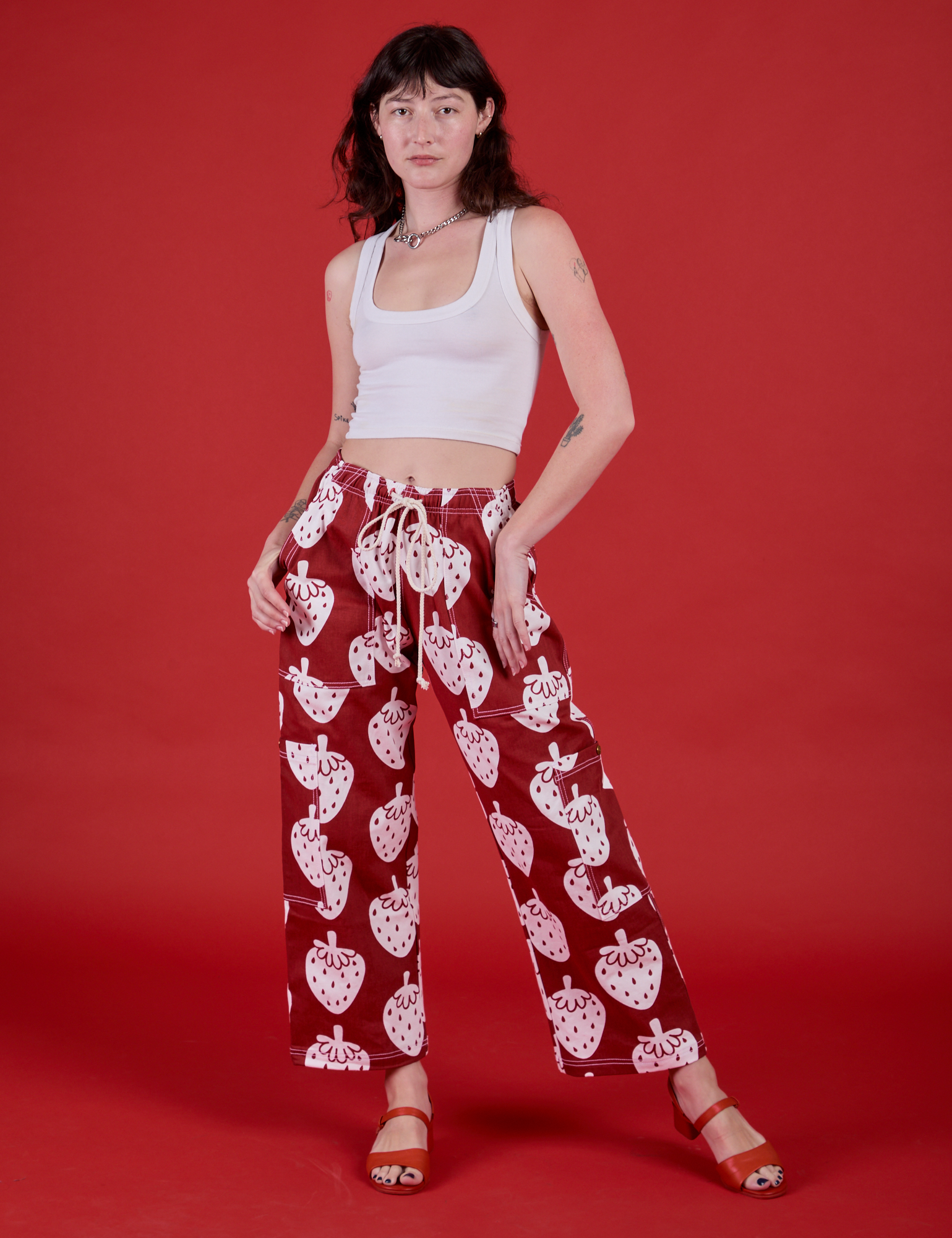 Alex is is 5'8" and wearing XXS Drop Pocket Pants in Strawbaby paired with. a vintage tee white Cropped Tank