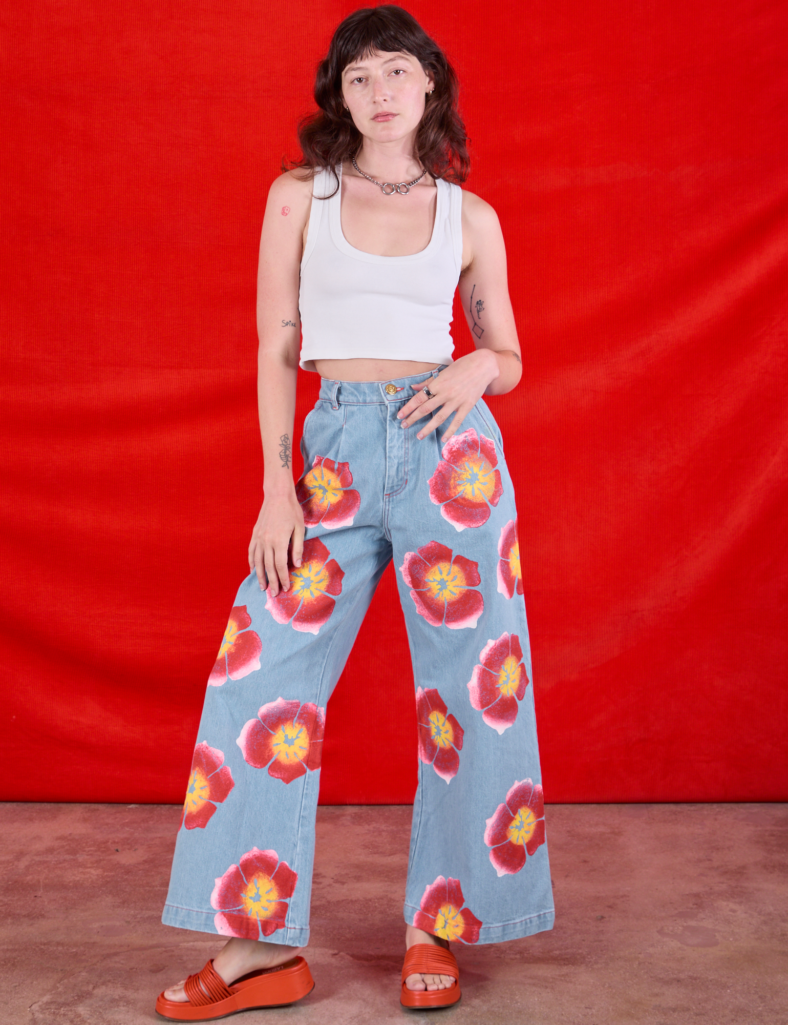 Alex is 5&#39;8&quot; and wearing XXS Wide Leg Denim Trousers in Painted Flowers paired with a Cropped Tank in Vintage Tee Off-White