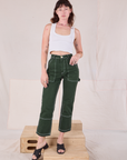 Alex is 5'8" and wearing XS Carpenter Jeans in Swamp Green paired with a Cropped Tank Top in Vintage Tee Off-White