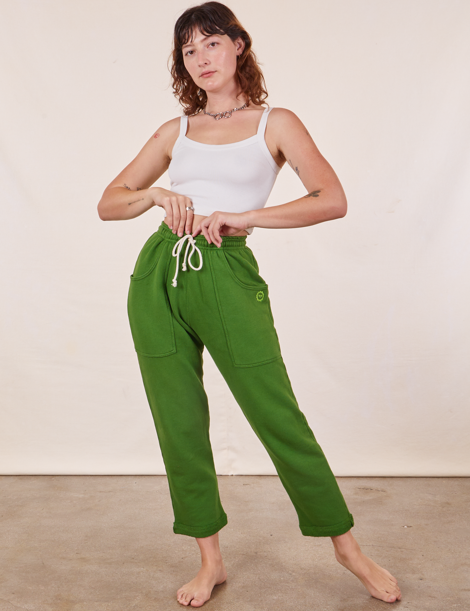 Alex is 5&#39;8&quot; and wearing XXS Cropped Rolled Cuff Sweatpants in Lawn Green paired with vintage off-white Cami