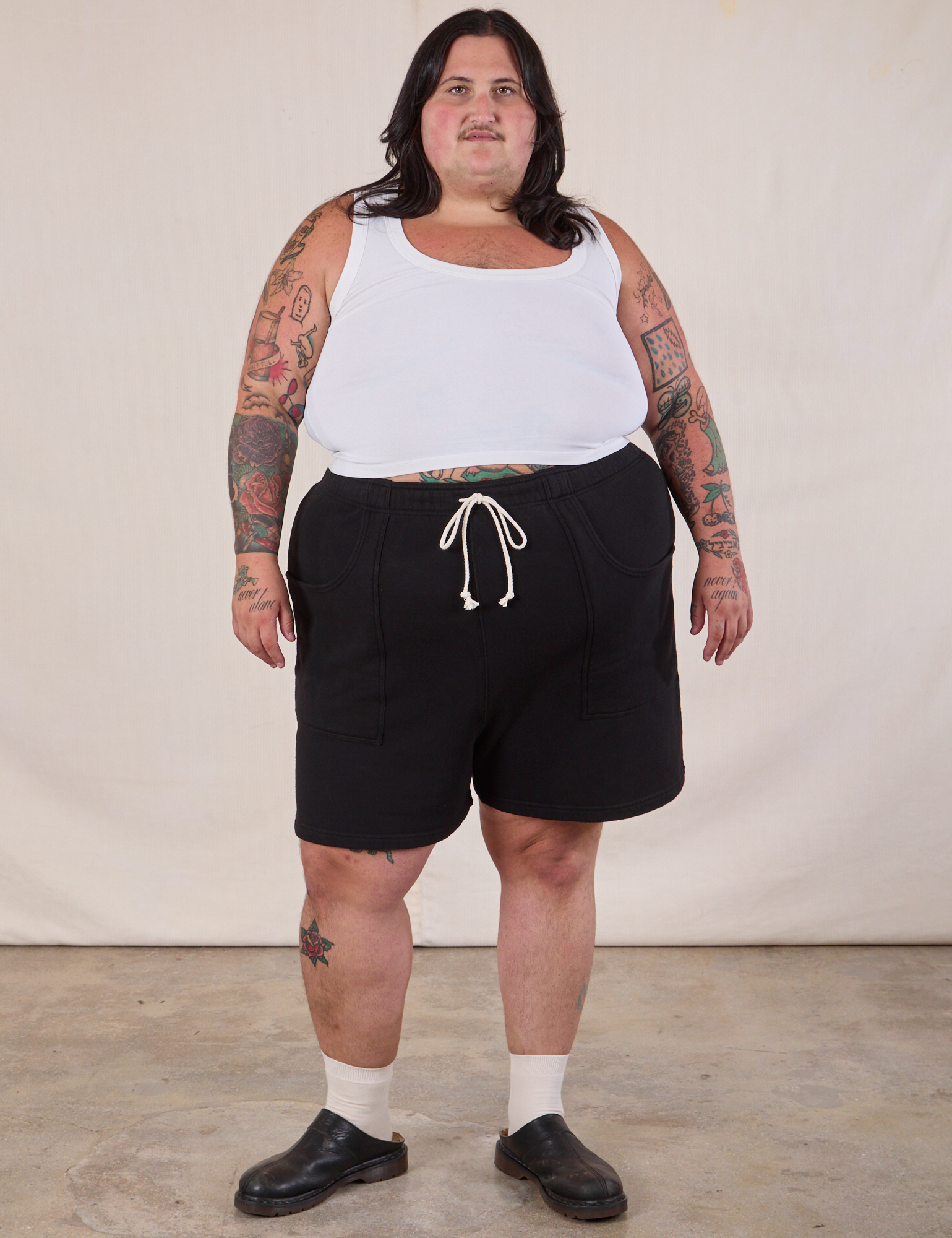 Sam is 5'10" and wearing 2XL Heavyweight Sweat Shorts in Basic Black paired with a Cropped Tank in Vintage Tee Off-White