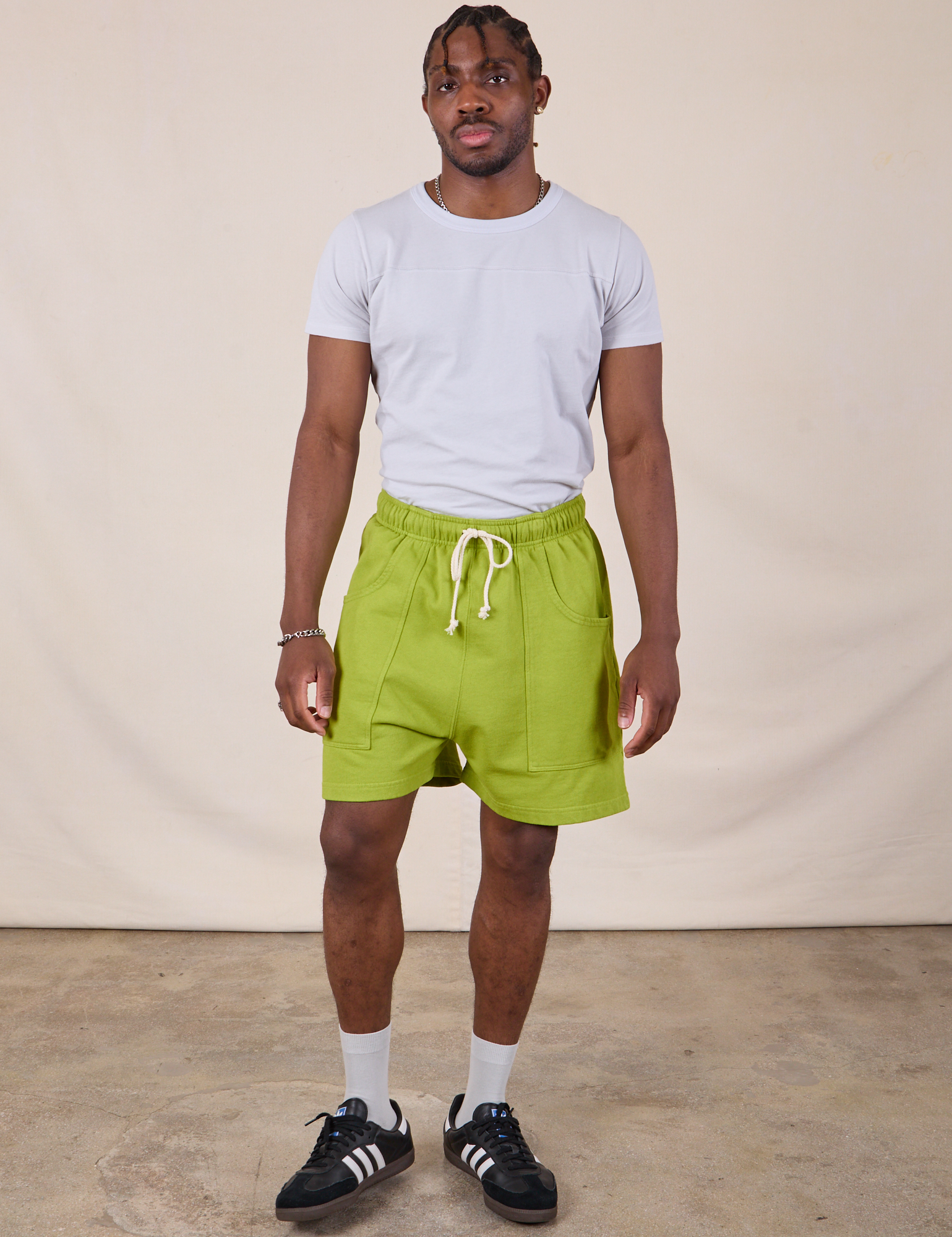 Isaac is 5&#39;10&quot; and wearing M Sweat Shorts in Gross Green paired with a stone white Jr. Varsity Tee