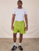 Isaac is 5'10" and wearing M Sweat Shorts in Gross Green paired with a stone white Jr. Varsity Tee