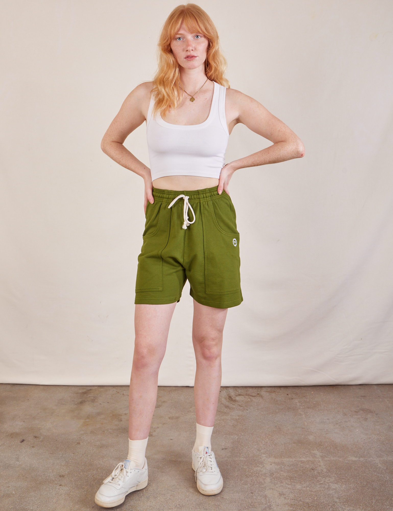 Margaret is 5’11” and wearing XXS Lightweight Sweat Shorts in Summer Olive paired with a Cropped Tank in vintage tee off-white